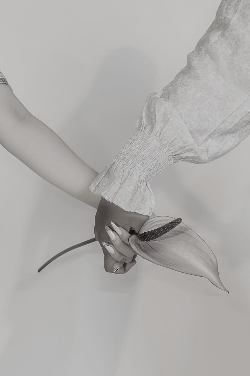 Women Holding Hands with Flower Close-up