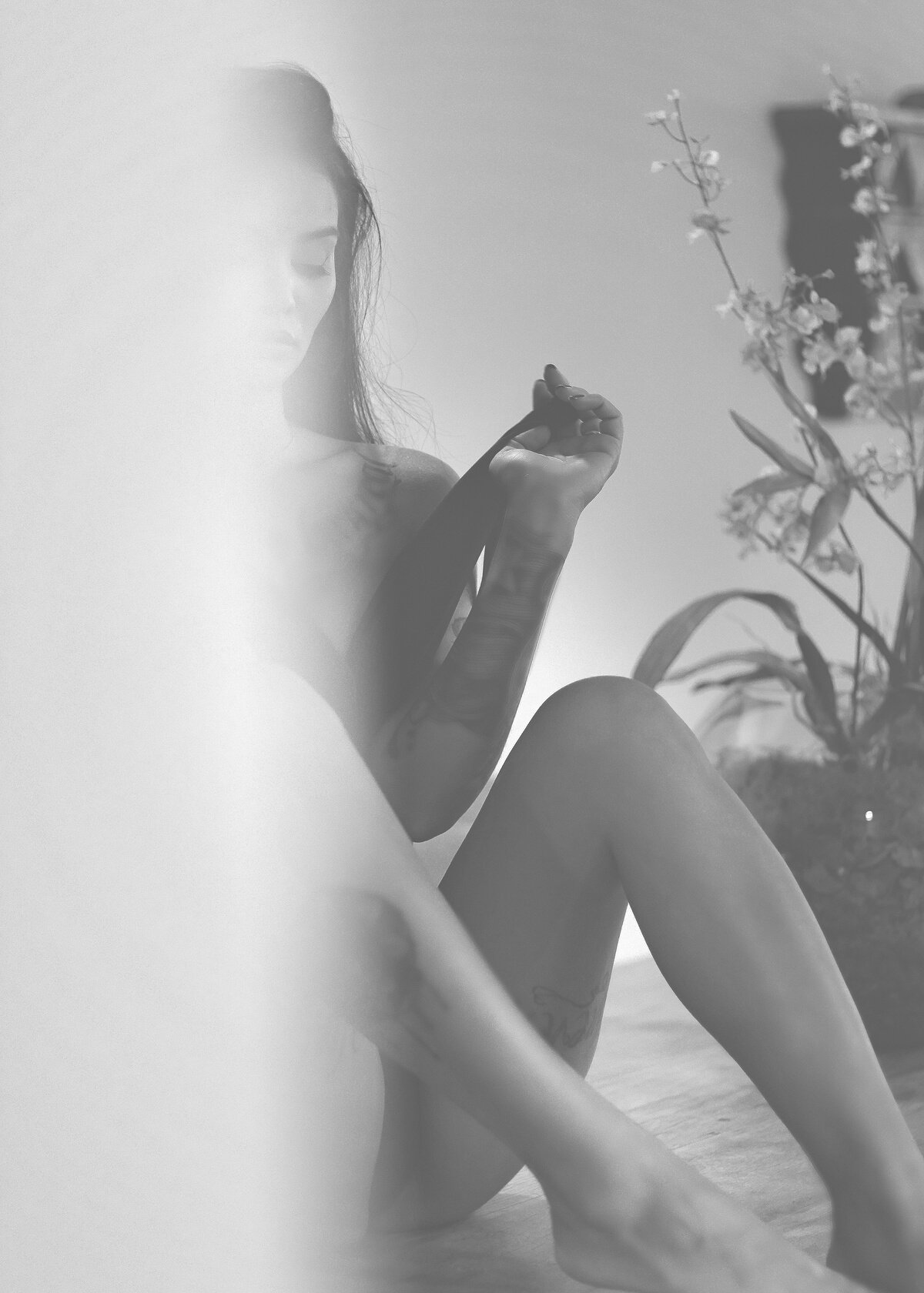 A Tattooed Woman in a Lingerie Sitting on the Floor